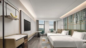 Een moderne hotelkamer met een groot bed, een bureau, een televisie en uitzicht op het omliggende landschap.