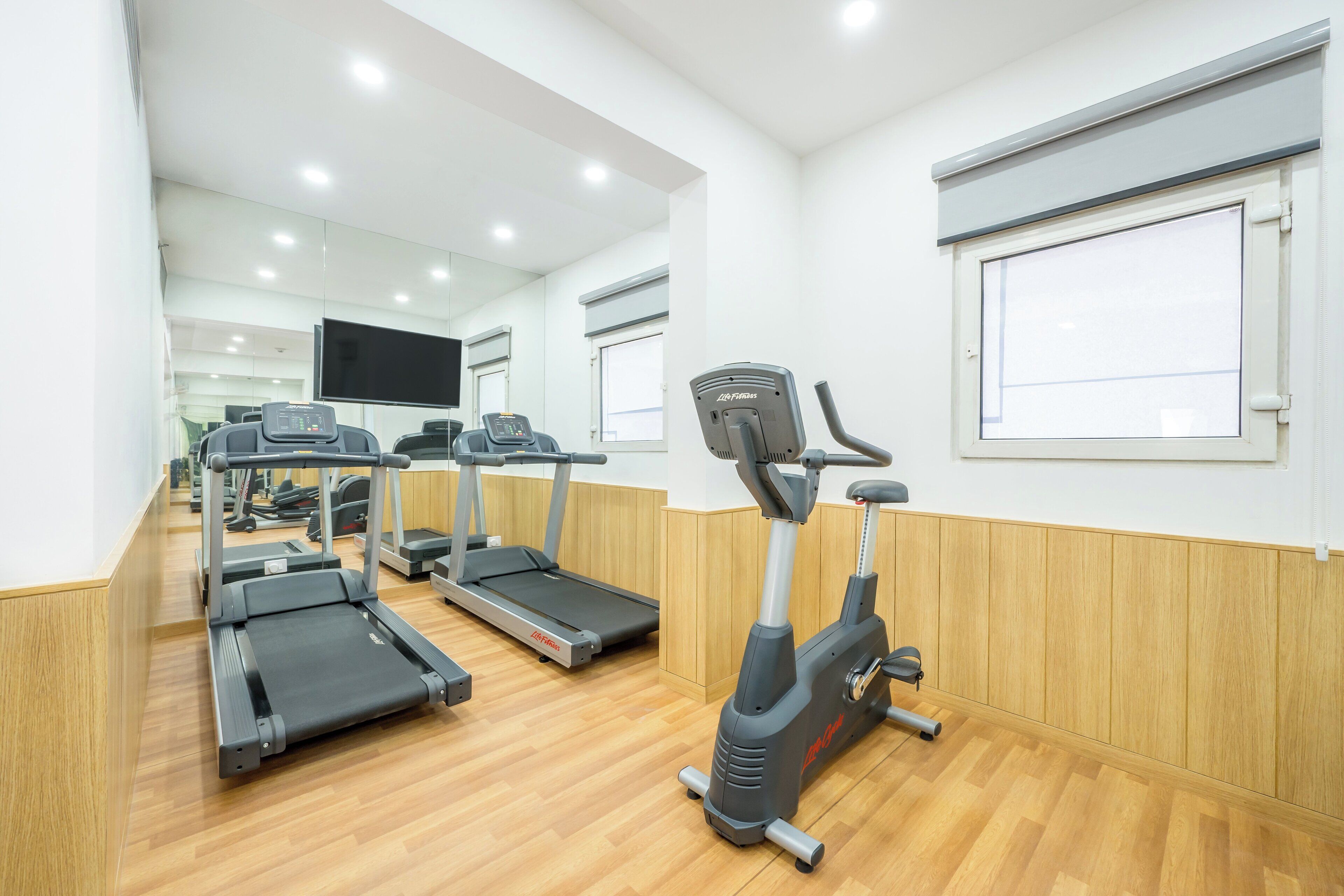 A gym with treadmills, an elliptical, and a stationary bike.