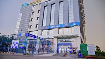 A modern building with a sign for 'Aakash' and 'Decathlon' on the ground floor.