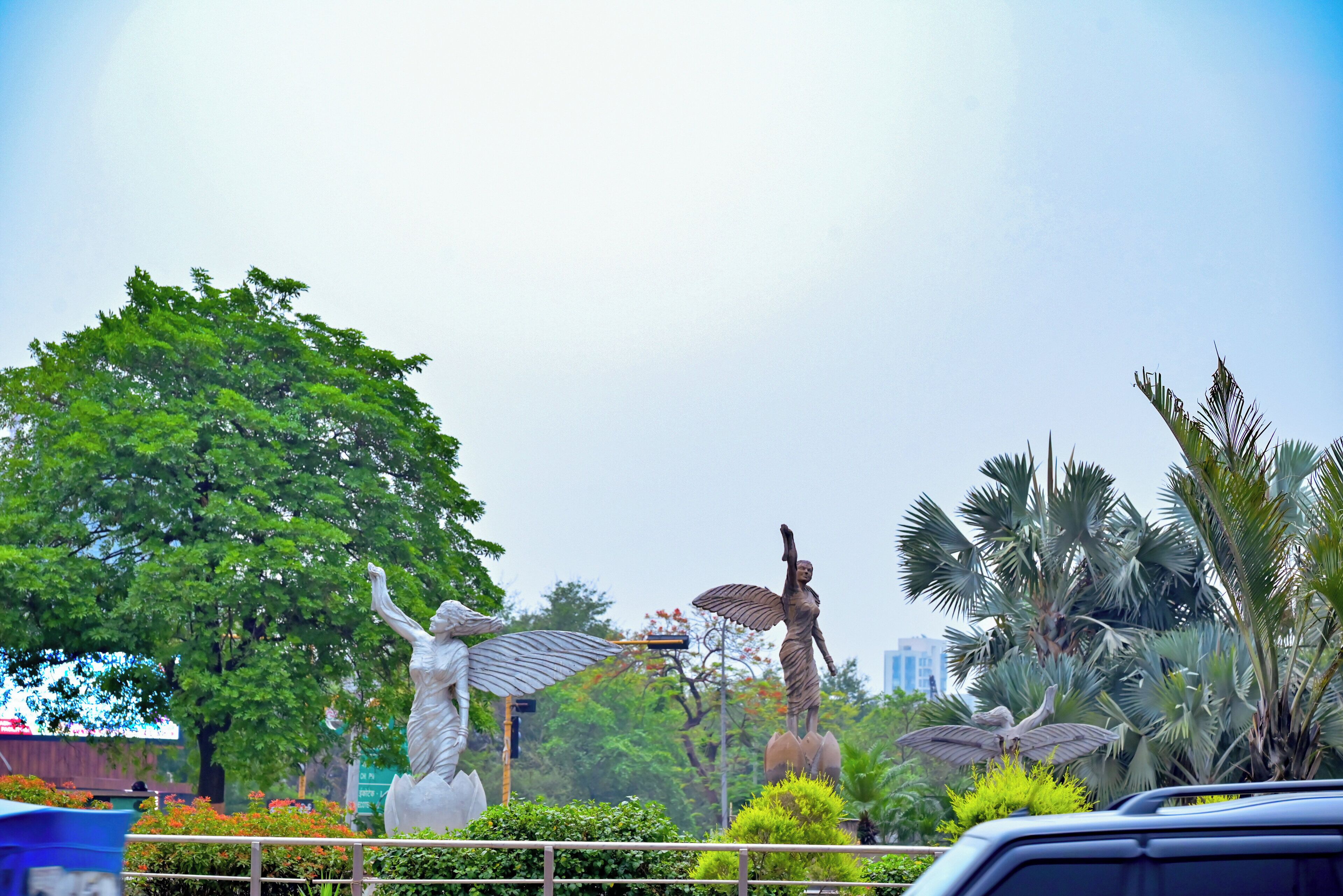 A statue of a woman with outstretched arms, a statue of a woman with wings, and a statue of a woman with a raised arm.