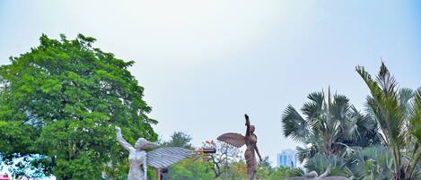 A statue of a woman with outstretched arms, a statue of a woman with wings, and a statue of a woman with a raised arm.