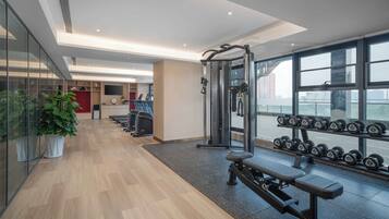 Een moderne sportschool met loopbanden, een squatsysteem en gewichten.