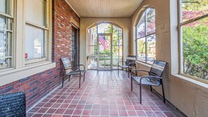 A covered outdoor area with brick walls, tiled flooring, and several benches. - Bluemoon Bungalow 2 Units (Memphis)