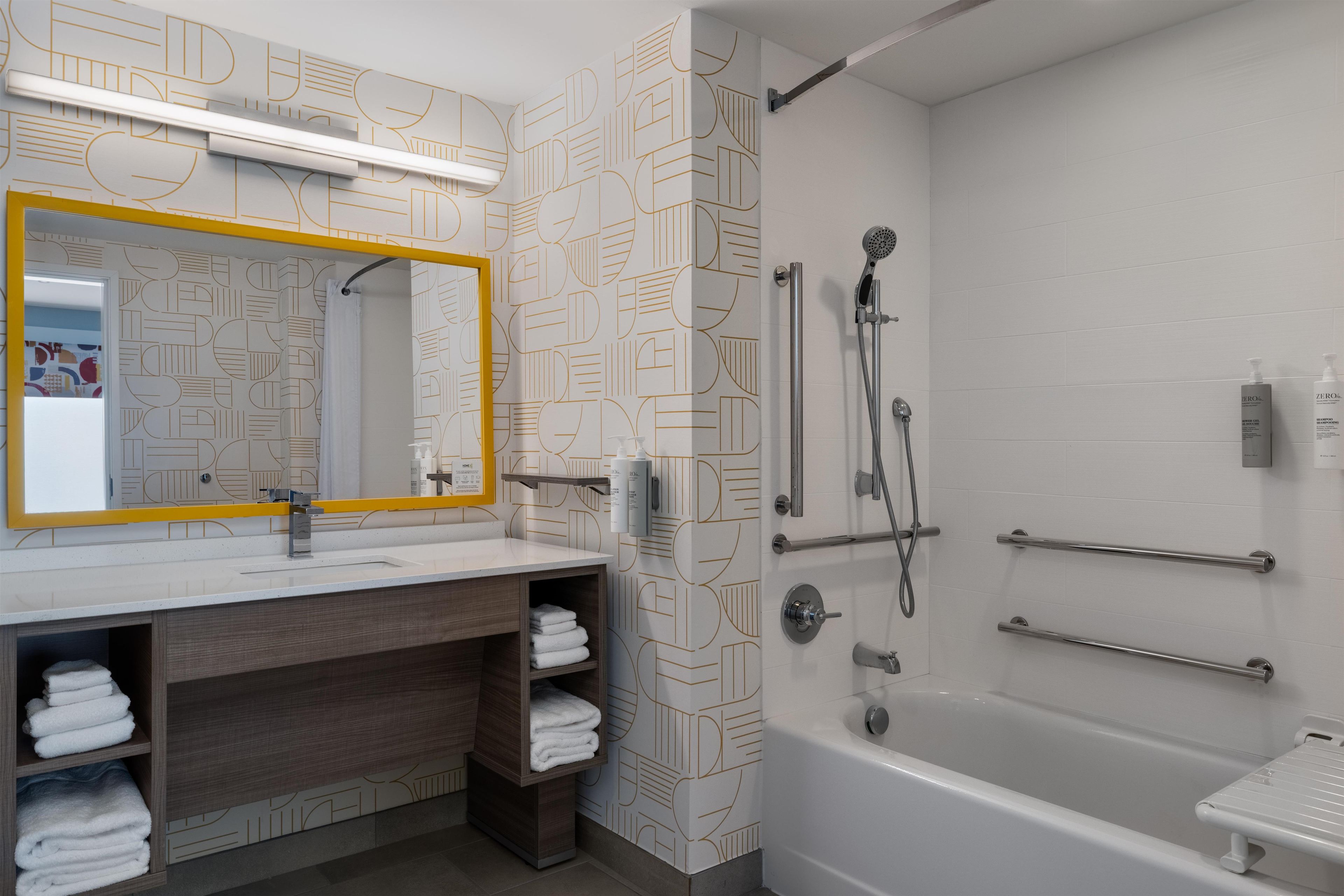 A modern bathroom with a large mirror, a shower, and a bathtub.