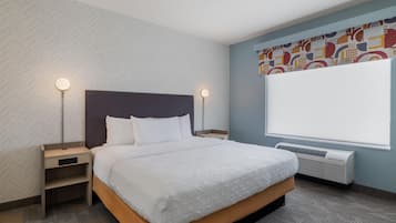 Ein Hotelzimmer mit Bett, Nachttischen, einem Heizkörper und einem Fenster mit Blick.