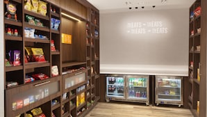 Ein Bereich zur Präsentation von Snacks und Getränken mit Regalen, die mit verschiedenen Speisen und Getränken gefüllt sind, sowie zwei Kühlvitrinen.
