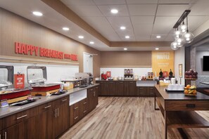 A breakfast area with a sign reading "HAPPY BREAKFAST START HERE" and a "HAMPTON WAFFLE" sign. - Hampton Inn Evergreen (Evergreen)