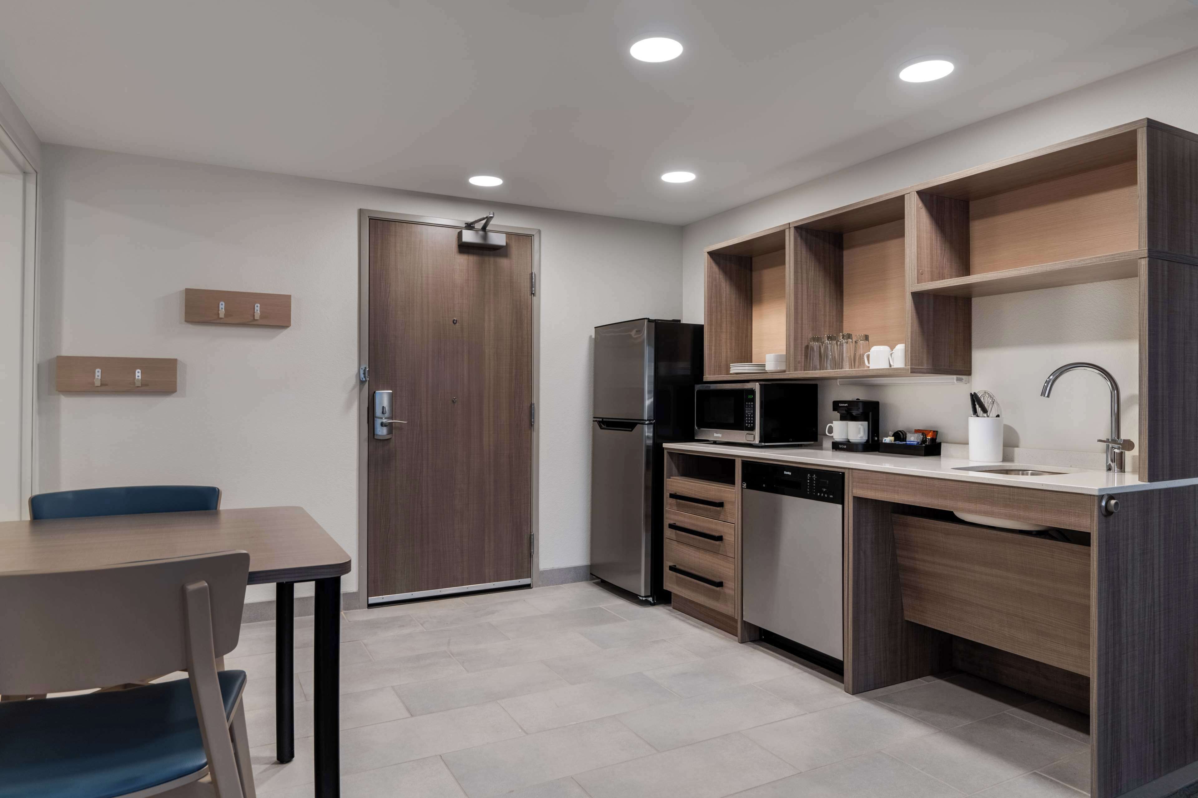 A modern kitchen with wooden cabinets, a refrigerator, a microwave, and a dishwasher.