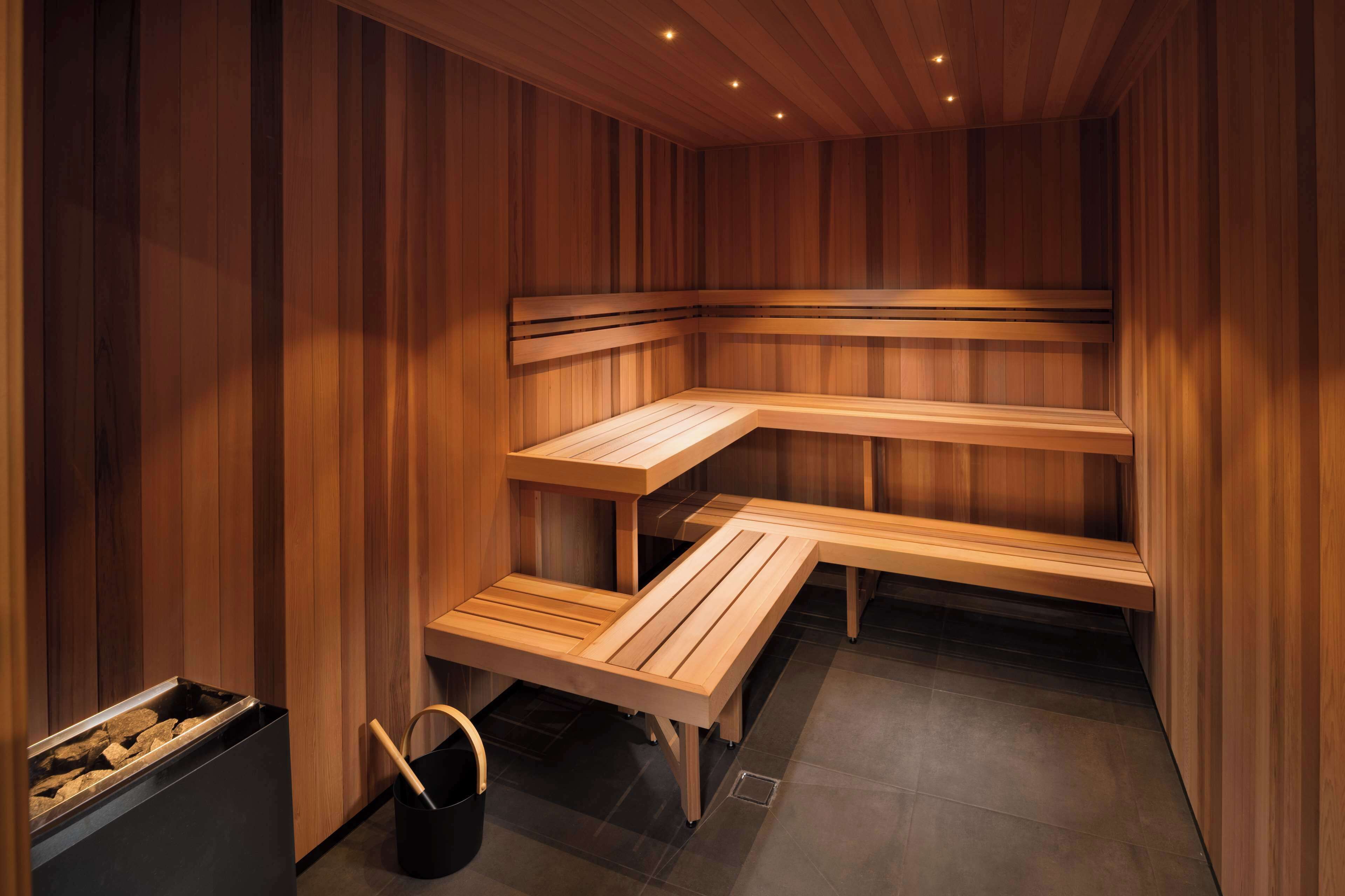Eine Sauna mit Holzbänken und einem Steingefäß.