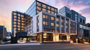 A modern hotel with a glass facade, multiple floors, and a prominent entrance. - Doubletree By Hilton Hobart (Hobart)