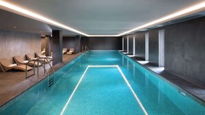 A modern indoor swimming pool with clear blue water, lounge chairs, and recessed lighting. - Doubletree By Hilton Hobart (Hobart)