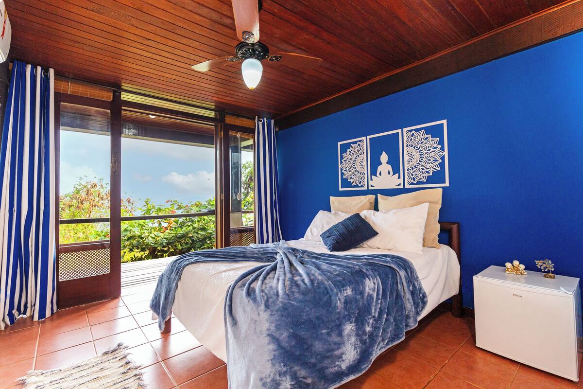 A bedroom with a bed, a nightstand, and a ceiling fan.