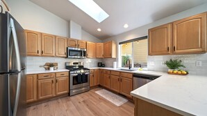 Una cocina moderna con armarios de madera, electrodomésticos de acero inoxidable y tragaluces.