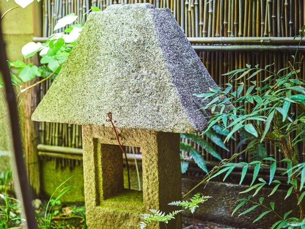 A stone lantern in a garden with bamboo and ferns.