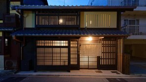 A traditional Japanese house with a tiled roof, wooden sliding doors, and a small balcony.