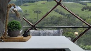 Une pièce offrant une vue sur un paysage montagneux, encadrée par une structure de fenêtre aux motifs géométriques.