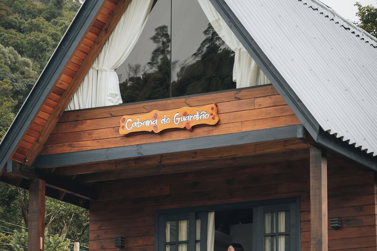 A wooden cabin with a sign reading "Cabana do Guadiao".