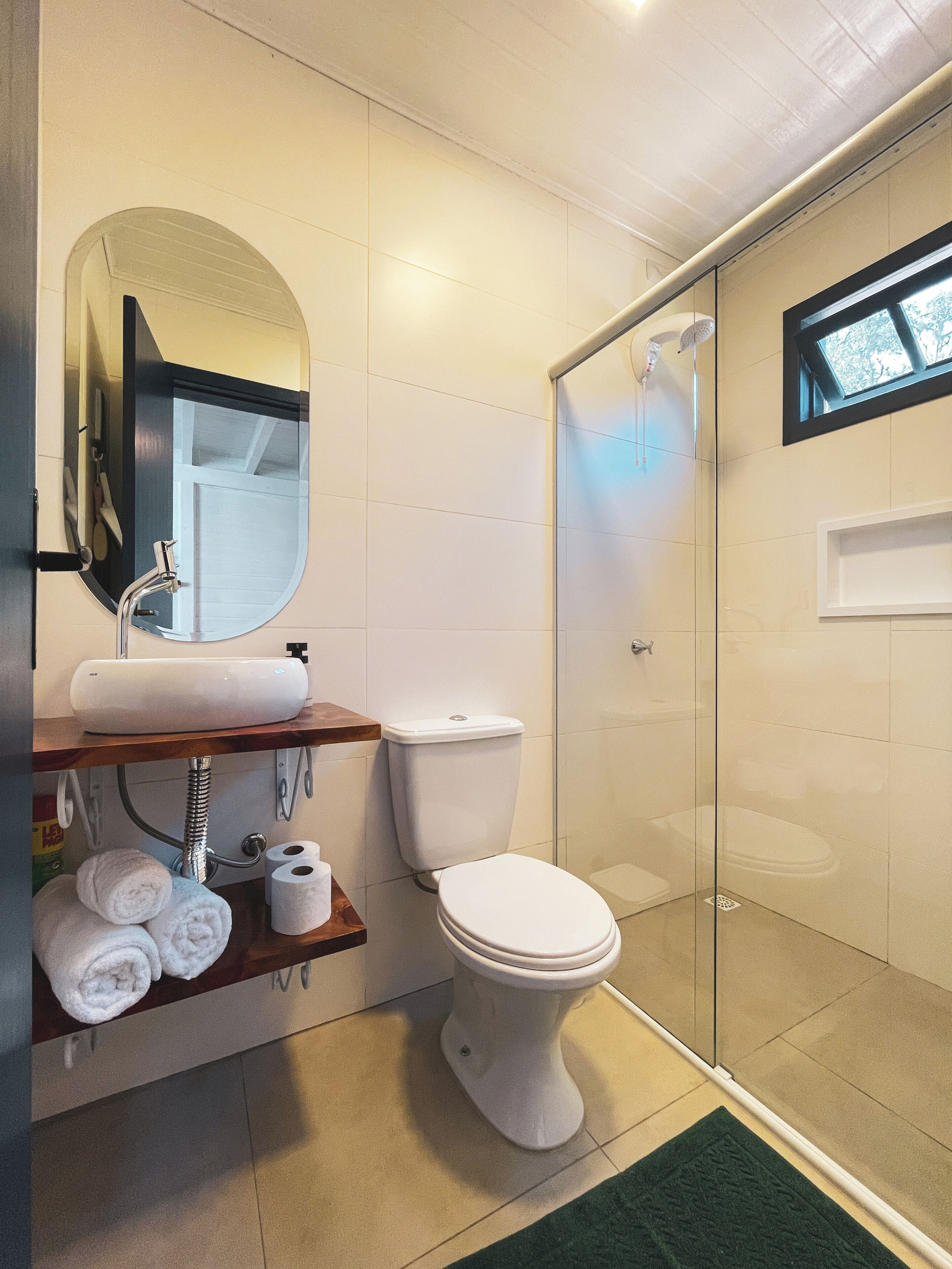 A modern bathroom with a toilet, sink, and shower.