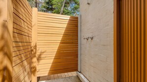 A wooden gate leading to a building with a beige exterior wall. - Home Sweet Holiday in Lilli Pilli (Lilli Pilli)
