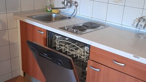 Eine Küche mit Geschirrspüler, Spüle und Herd.