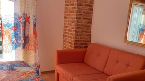 Ein Zimmer mit Backsteinwand, einer Couch und einem gemusterten Teppich.