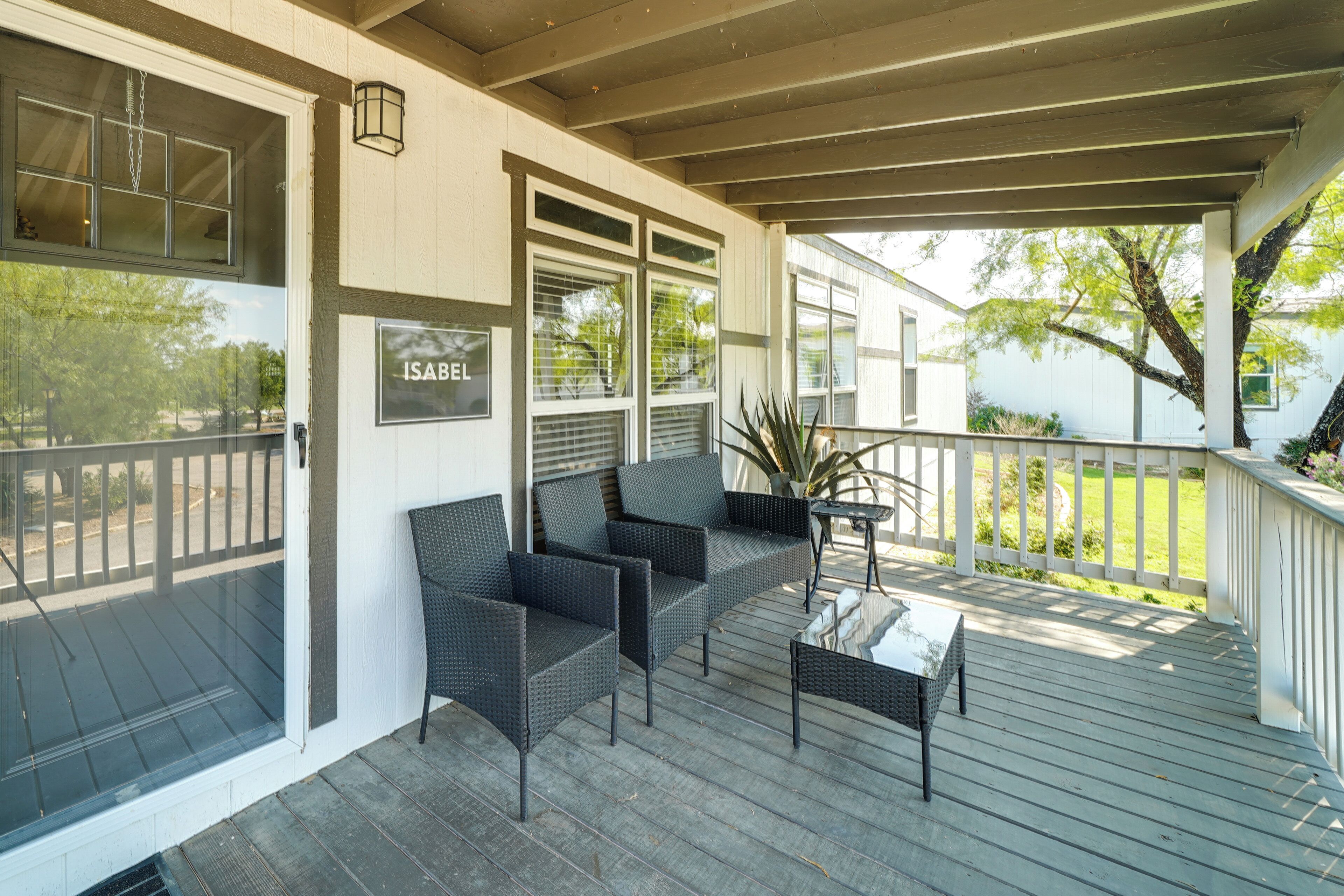 A covered porch with wicker furniture and a sign reading "ISABEL".
