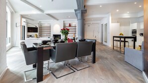 Un espace repas moderne avec une table centrale, des chaises et un vase décoratif.