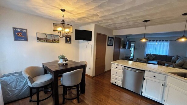 A compact kitchen with a dining area, wooden flooring, and a ceiling with a unique texture. - Alumni Corner

 (State College)