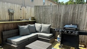A backyard with a sectional sofa, a grill, and a wooden deck. - Alumni Corner

 (State College)