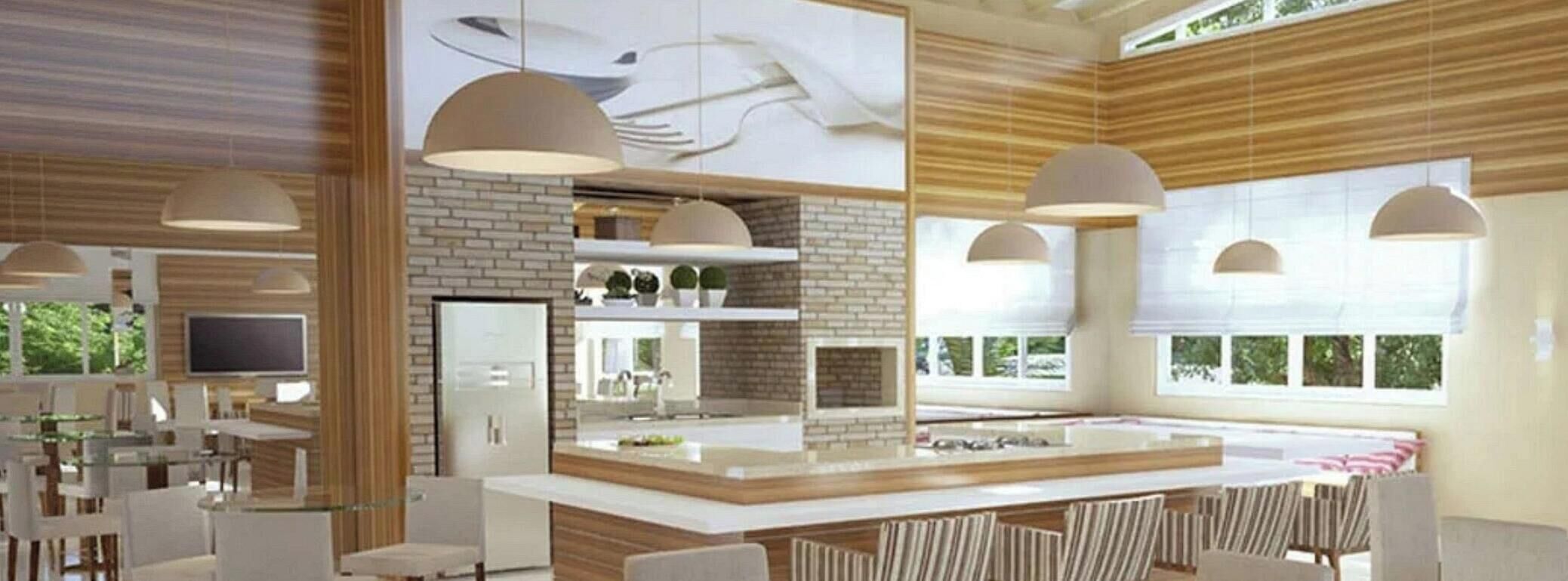 Una cocina moderna con una isla central, iluminación colgante y vistas al exterior.