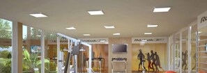 A gym with exercise equipment, glass walls, and Reebok and Reebok XT logos. - Rosa Internacional - Surfland (Garopaba)