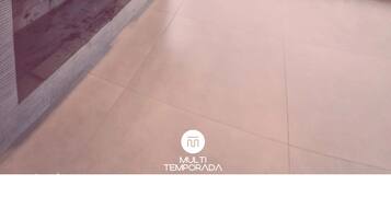 Uma sala de estar moderna com televisão de tela plana, lareira, sofá e área de jantar.