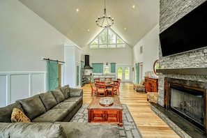 A spacious living area with a fireplace, a dining table, and a sofa.