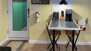 A compact kitchen with a dining table, chairs, a coffee maker, and a fire extinguisher. - Great Mid-Town Toronto Bachelor Suite Convenient to Downtown and Airport (Toronto)