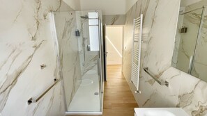 A modern bathroom with a glass shower enclosure, a white sink, and a large mirror. - Color Houses Pescara Centro (Pescara)