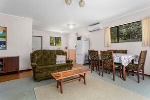 Cozy living space with a kitchenette, sofa, and dining table for four.