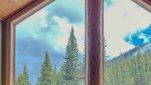 A large window with a view of a forested mountain range. - Apex Mountain ~ Ubuntu at Apex (Keremeos)