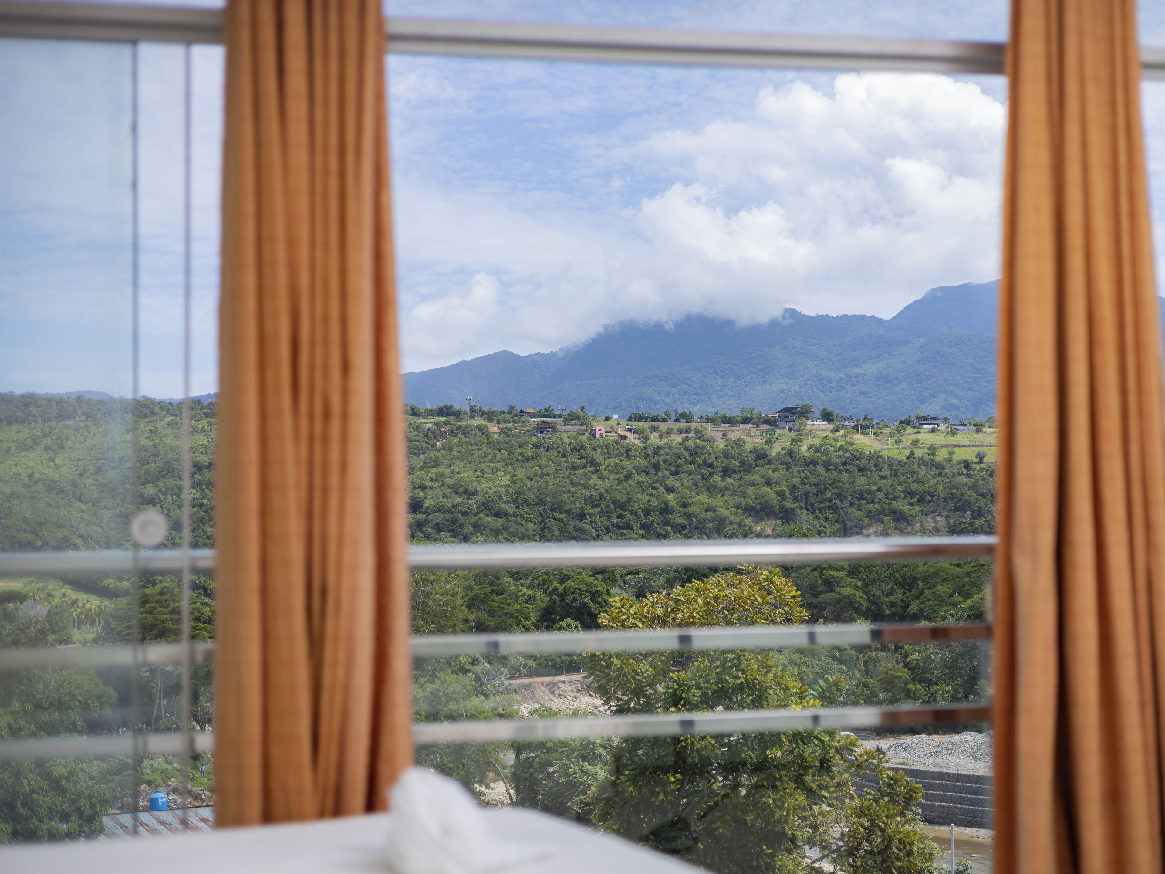 A room with a large window overlooking a mountainous landscape.