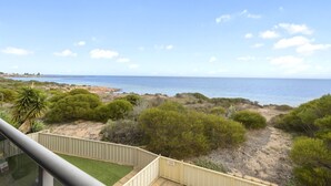 A balcony with a view of the sea, surrounded by greenery and a sandy path. - The Cove, Port Hughes (Port Hughes)