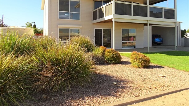 A two-story house with a covered front porch, a garage, and a well-maintained lawn. - Shell Seeker, Moonta Bay (Moonta Bay)