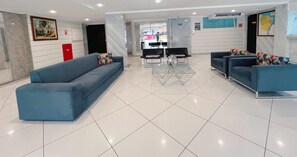 Relax in the stylish lobby, featuring a reception area, comfortable seating, and a map for easy navigation.