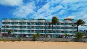 A multi-story hotel with a curved facade, balconies, and a beach view. - Manaíra Palace- LikeHome Hospedagens (João Pessoa)