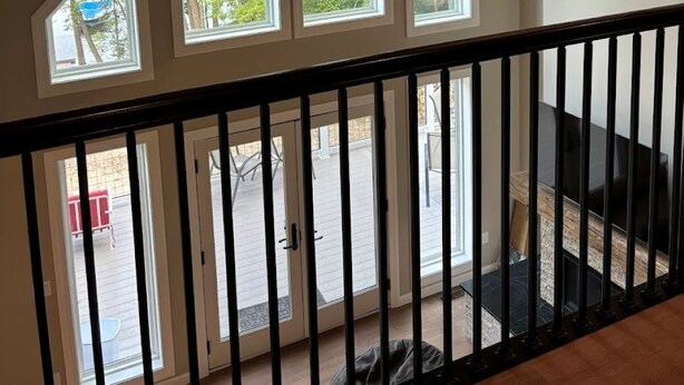 A room with a sloped ceiling, large windows, and a view of the outdoors. - The Beach House on Shaws Pond - gorgeous new home directly on the water (New Durham)