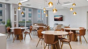 A modern conference room with round tables and leather chairs, large windows, and hanging spherical light fixtures. - Amazing spacious unit (Miami)