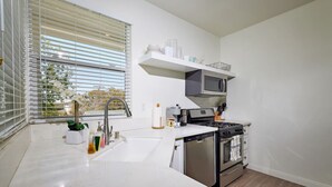 Une cuisine moderne équipée d’un lave-vaisselle intégré, d’une cuisinière et d’un four à micro-ondes.
