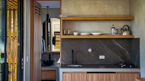 Eine moderne Küche mit Holzschränken, einer Marmor-Spritzschutzwand und einem eingebauten Herd.
