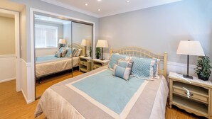 A bedroom with a large bed, two bedside tables, a mirror, and a wardrobe. - Secluded Private Suite in Bridle Trails – Near Major Tech & 25 Min to Seattle (Bellevue)