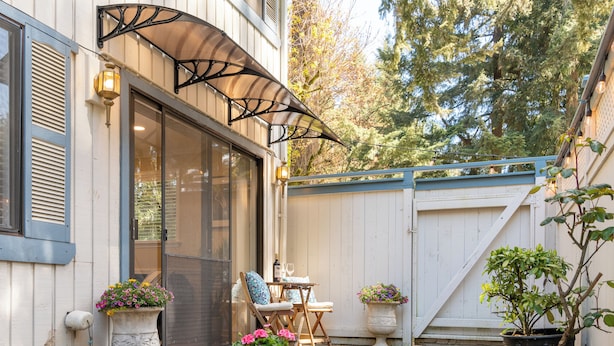 A patio area with a covered seating area, a potted plant, and a door leading to a screened-in porch. - Secluded Private Suite in Bridle Trails – Near Major Tech & 25 Min to Seattle (Bellevue)