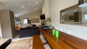 Cozy living space with a high ceiling, dining table, and comfortable sofas.