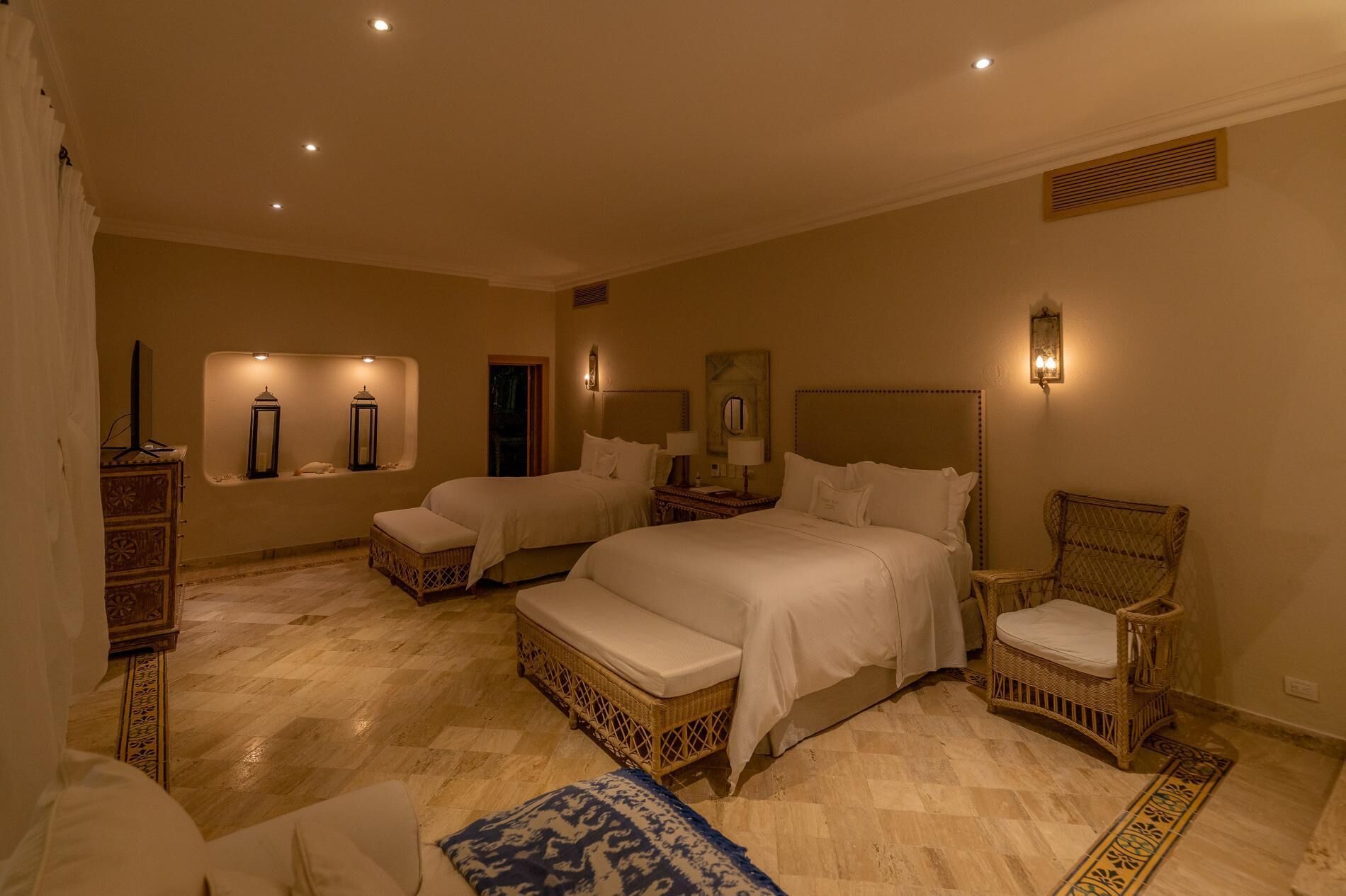 Une chambre d’hôtel avec deux lits, une chaise, une commode et un miroir.